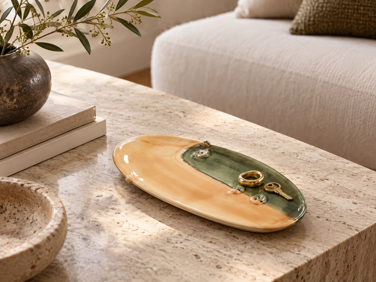 Hand-glazed oval dish in ochre and green on a travertine table